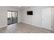 Comfortable bedroom showcasing wood-look floors, a ceiling fan, and sliding doors to the outdoor patio at 576 Belltower Ave # 100, Deltona, FL 32725