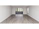 Spacious living room featuring wood floors and sliding glass doors leading to a screened patio at 576 Belltower Ave # 100, Deltona, FL 32725