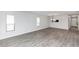 Spacious living room with wood-look floors and modern light fixture; perfect for relaxing and entertaining at 576 Belltower Ave # 100, Deltona, FL 32725