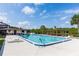 Community pool featuring plenty of seating for residents with a bath house and palm trees on a sunny day at 576 Belltower Ave # 100, Deltona, FL 32725