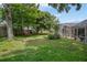 Backyard features include a well-maintained lawn, mature trees, and screened-in porch at 5776 White Acres Ln, Port Orange, FL 32127