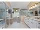 Bright bathroom featuring dual sinks, a walk-in shower, and a soaking tub at 5776 White Acres Ln, Port Orange, FL 32127