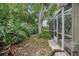 Exterior view of the screened-in porch and yard featuring mature trees and landscaping at 5776 White Acres Ln, Port Orange, FL 32127