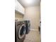 Well-lit laundry room featuring a washer, dryer, sink, and storage cabinets at 5776 White Acres Ln, Port Orange, FL 32127