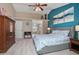 Spacious main bedroom featuring a blue accent wall, ceiling fan, and comfortable bedding at 5776 White Acres Ln, Port Orange, FL 32127