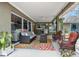 Inviting covered patio with comfortable seating, colorful rug, and outdoor grill, perfect for relaxing and entertaining at 5776 White Acres Ln, Port Orange, FL 32127