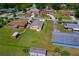 Aerial view of the home with large, green lawn, shed and long driveway in a neighborhood setting at 707 Hamilton St, New Smyrna Beach, FL 32168