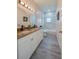 Bathroom with double sinks, granite counters, and a shower with textured white tiling at 707 Hamilton St, New Smyrna Beach, FL 32168
