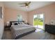 Staged bedroom with gray queen-sized bed and view of backyard at 707 Hamilton St, New Smyrna Beach, FL 32168