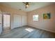 Bright bedroom featuring gray laminate flooring, ceiling fan, and white closets at 707 Hamilton St, New Smyrna Beach, FL 32168