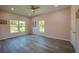 Well-lit bedroom with two large windows, ceiling fan, and wood-look floors at 707 Hamilton St, New Smyrna Beach, FL 32168