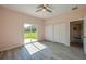 Bedroom featuring gray laminate flooring, ceiling fan, and sliding glass doors to the yard at 707 Hamilton St, New Smyrna Beach, FL 32168