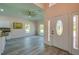 Bright foyer with decorative front door, wood floors, and views into the living spaces at 707 Hamilton St, New Smyrna Beach, FL 32168
