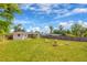 Large backyard with well-kept lawn, fire pit with Adirondack chairs, and partial fencing at 738 Lindley Blvd, Deland, FL 32724