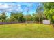 Lush backyard with mature trees, grass, and a storage shed behind wood fence at 738 Lindley Blvd, Deland, FL 32724