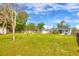 Expansive backyard with mature trees, fire pit seating, and screened-in porch at 738 Lindley Blvd, Deland, FL 32724