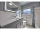 Well-lit bathroom with a gray vanity, large mirror, and white tile at 738 Lindley Blvd, Deland, FL 32724