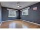 Sleek bedroom showcasing hardwood floors, ceiling fan, and natural light from two windows at 738 Lindley Blvd, Deland, FL 32724