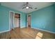 Bright bedroom with hardwood floors, ceiling fan, closet, and access to a hallway at 738 Lindley Blvd, Deland, FL 32724
