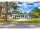Charming single-story home featuring a screened in porch, well-manicured lawn, and solar panels at 738 Lindley Blvd, Deland, FL 32724