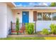 Inviting front porch with a bright blue door, stylish light fixture, and well-kept landscaping at 738 Lindley Blvd, Deland, FL 32724
