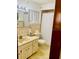 Bathroom features light-colored tile, a single sink vanity, and a toilet at 7380 Orange Ave, Indian Lake Estates, FL 33855