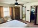 Bright bedroom with a window, ceiling fan, and bamboo-style furnishings at 7380 Orange Ave, Indian Lake Estates, FL 33855