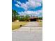 Inviting home with a long driveway and a neatly kept lawn leading to a tile-roofed residence at 7380 Orange Ave, Indian Lake Estates, FL 33855