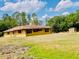 Single-story home with an outbuilding, set on a verdant lot, blending comfort with rustic charm at 7380 Orange Ave, Indian Lake Estates, FL 33855