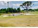 Picturesque community fountain surrounded by lush green lawns and mature trees at 7380 Orange Ave, Indian Lake Estates, FL 33855