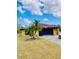 Single-story home with a palm tree in the front yard and a paved driveway, offering a welcoming curb appeal at 7380 Orange Ave, Indian Lake Estates, FL 33855