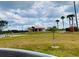 Scenic view of an Indian Lake Estates home with lush green landscaping and palm trees at 7380 Orange Ave, Indian Lake Estates, FL 33855