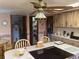 Kitchen with wood cabinets, island cooktop, and views of a pantry and utility room at 7380 Orange Ave, Indian Lake Estates, FL 33855