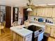 Functional kitchen boasts wooden cabinetry, a central island with cooktop, and ample counter space at 7380 Orange Ave, Indian Lake Estates, FL 33855