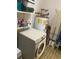Laundry room with appliances, shelving, and an ironing board at 7380 Orange Ave, Indian Lake Estates, FL 33855
