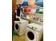 Laundry room with side by side Samsung washing machines and ample shelving at 7380 Orange Ave, Indian Lake Estates, FL 33855
