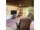Spacious living room with wood-beamed ceilings and access to the backyard through sliding glass doors at 7380 Orange Ave, Indian Lake Estates, FL 33855