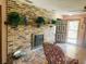 Cozy living room features a brick fireplace and a welcoming entrance with a charming chair at 7380 Orange Ave, Indian Lake Estates, FL 33855