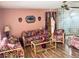Cozy living room features floral furniture, wood flooring, and decorative wall hangings at 7380 Orange Ave, Indian Lake Estates, FL 33855