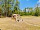 Exterior view of the shed in the yard, surrounded by a large grassy area and trees at 7380 Orange Ave, Indian Lake Estates, FL 33855