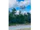 View of the Indian Lake Estates water tower surrounded by lush trees under a partly cloudy sky at 7380 Orange Ave, Indian Lake Estates, FL 33855