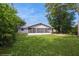 Landscaped backyard featuring lush grass and a screened in porch at 810 Sylvia Dr, Deltona, FL 32725
