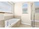 Bright bathroom featuring a soaking tub, glass shower, and large windows at 8832 Ribault Ave, Orlando, FL 32832