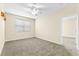 This bedroom offers neutral walls, carpet, ceiling fan, and natural light at 8832 Ribault Ave, Orlando, FL 32832