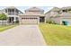 A two-story home boasting a large garage, screened lanai, well-maintained lawn, and paved driveway at 8832 Ribault Ave, Orlando, FL 32832