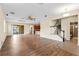 Bright, open-concept living room with hardwood floors, adjacent to kitchen, staircase, and full bathroom at 8832 Ribault Ave, Orlando, FL 32832