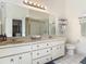 Bathroom with double vanity sinks, large mirror, and a walk-in shower at 907 Silver Leaf Pl, Port Orange, FL 32127