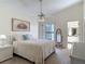 Bright bedroom with a ceiling fan, painting, a sliding door to the outside, and an ensuite bathroom at 907 Silver Leaf Pl, Port Orange, FL 32127