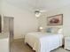 Bright bedroom features a ceiling fan, a painting, and neutral carpeting at 907 Silver Leaf Pl, Port Orange, FL 32127