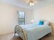 Bedroom features a brass bed frame, a ceiling fan, and a large window at 907 Silver Leaf Pl, Port Orange, FL 32127